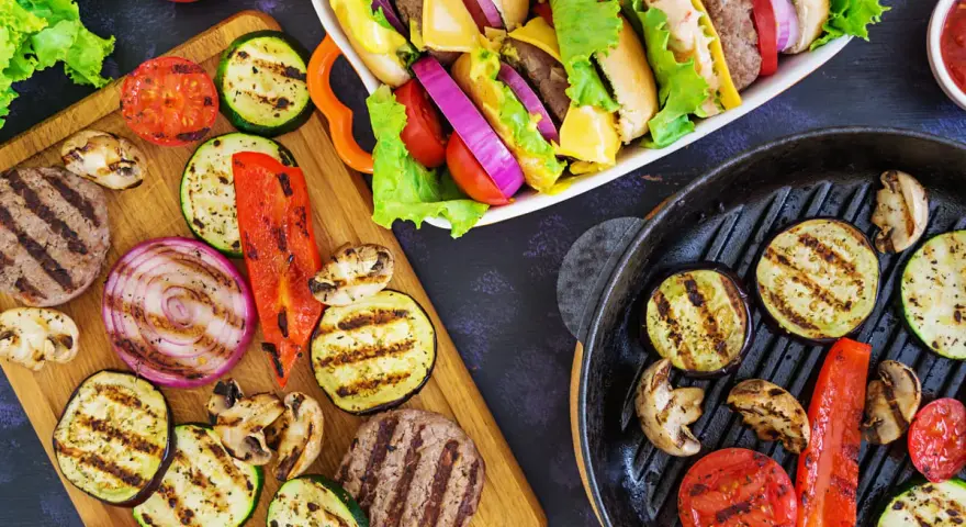 Pyszne przekąski na grilla: burgery, grillowane warzywa (cukinia, bakłażan, papryka, cebula, pomidory) i pieczarki. Idealne na letnie spotkania.