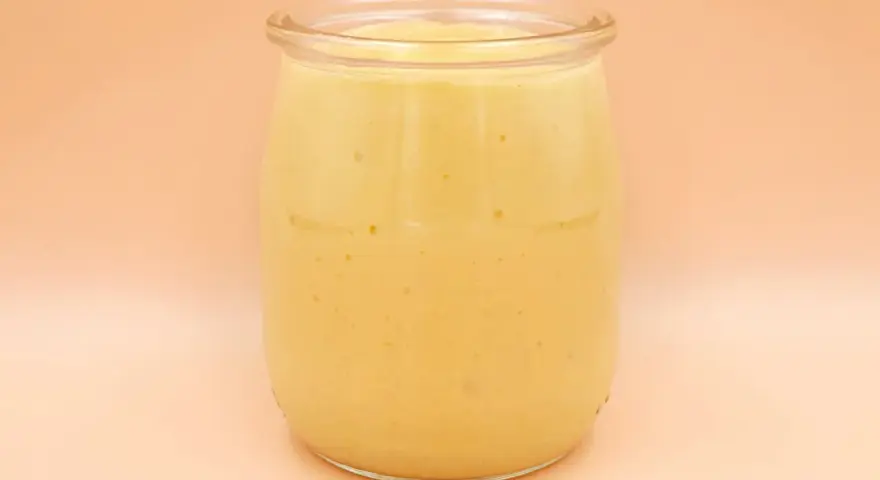 Gęsty, kremowy mango lassi w szklanym słoiku, gotowy do orzeźwiającego łyku.