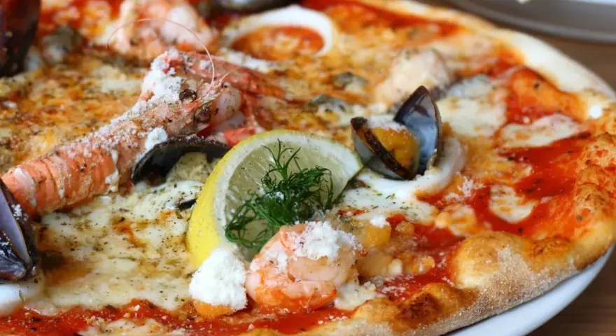 Wykwintna pizza z krewetkami, małżami i cytryną – być może najdroższa pizza na świecie, kusząca bogactwem owoców morza.