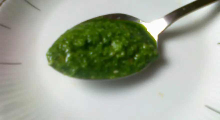Łyżeczka pełna aromatycznego pesto z pietruszki, gotowa do podania.
