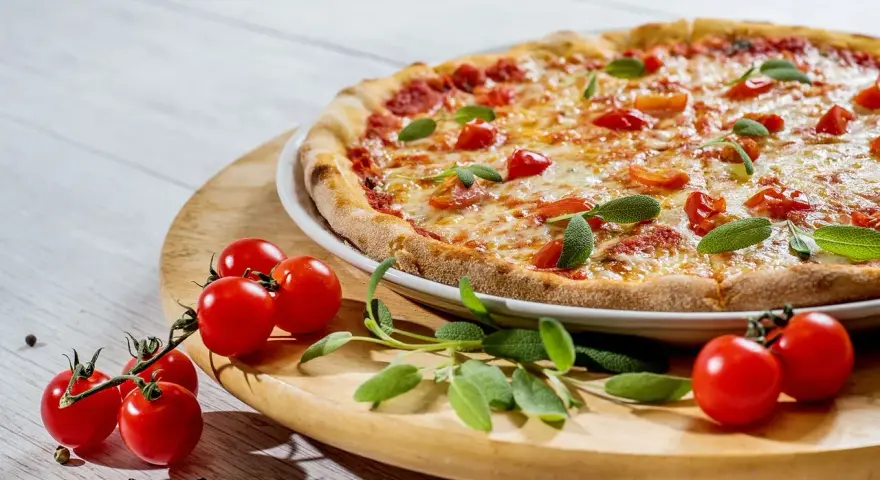 Pyszna pizza z pomidorkami i szałwią. Idealne jakie zioła do pizzy, by nadać jej śródziemnomorski smak.