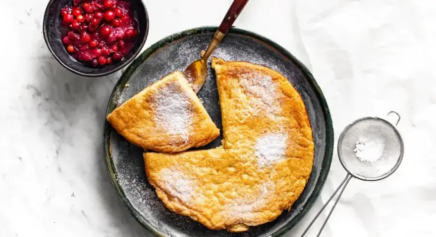 Puszysty omlet z airfryer, posypany cukrem pudrem, podany z żurawiną. Idealny na śniadanie.