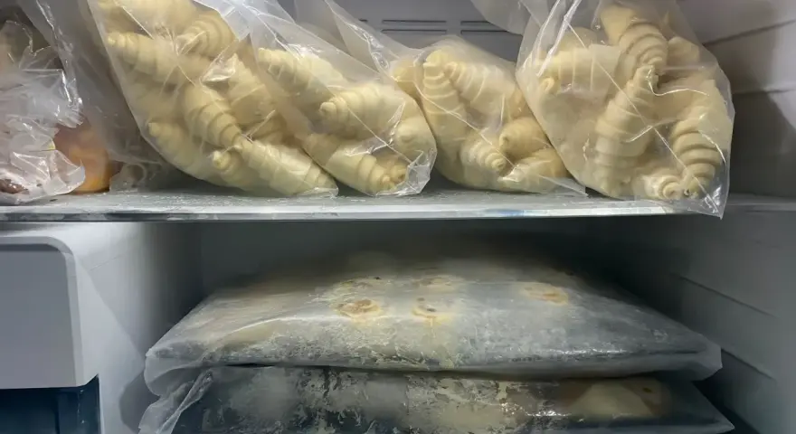 Surowe ciasto drożdżowe w woreczkach w zamrażarce.