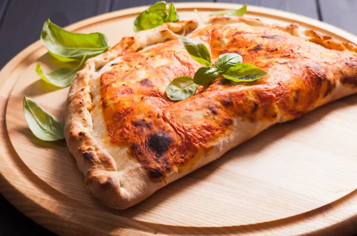 Złocisty calzone z sosem pomidorowym i bazylią, pyszna pizza, której kcal nie zrujnują diety.