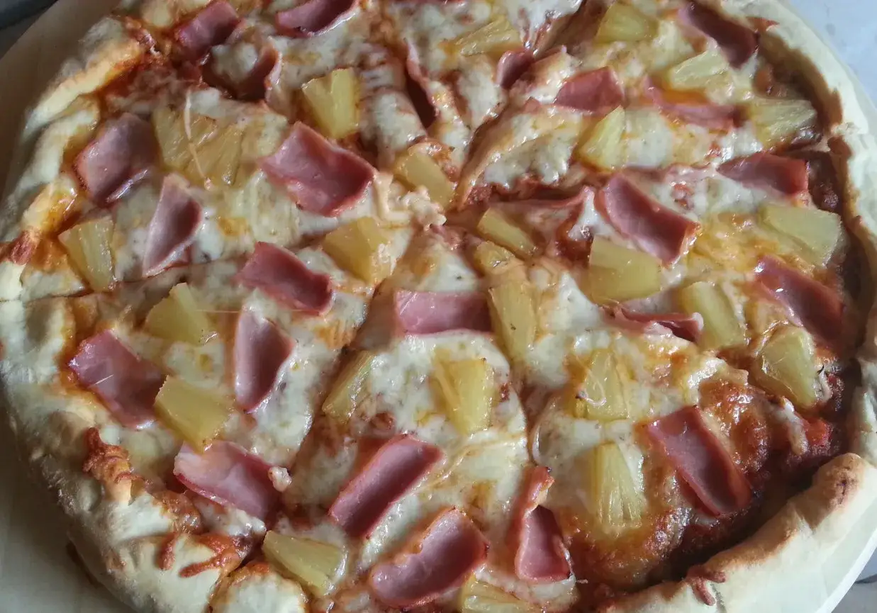 Pyszne pizze z ananasem i szynką, pokryte ciągnącym się serem. Idealne na szybki obiad lub kolację.
