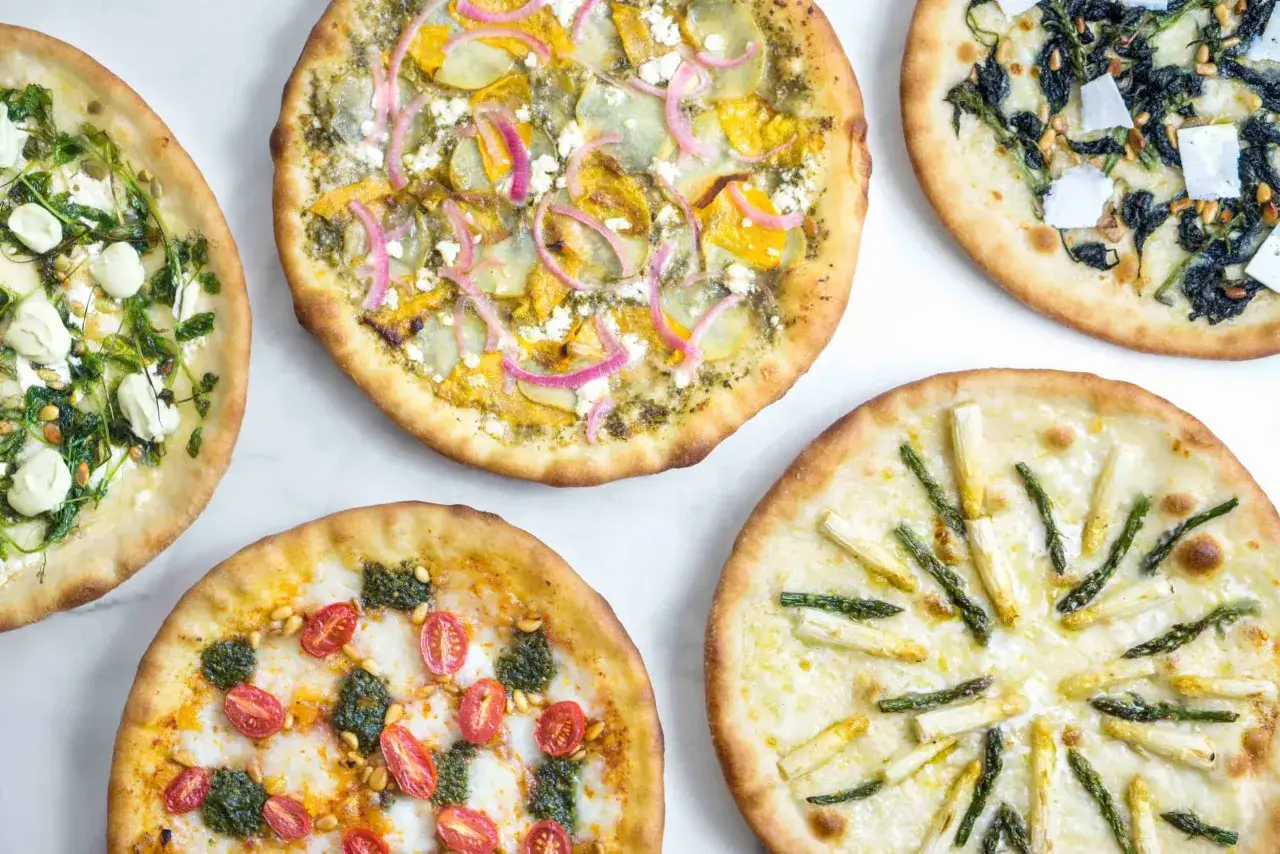 Pięć różnych pizz z bogactwem dodatków: pomidorki, szparagi, szpinak, dynia i ser. Idealne dla miłośników różnorodnych smaków pizzy.