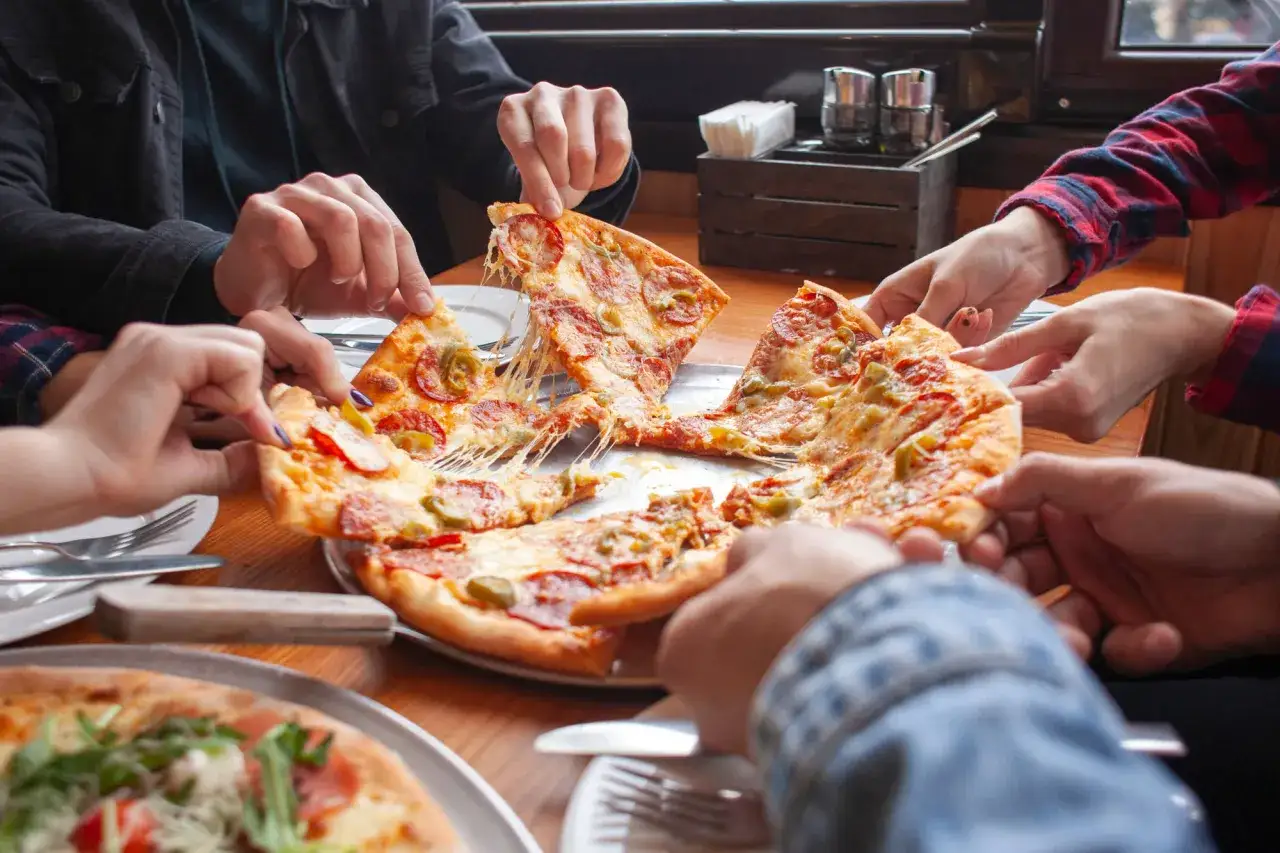 Ręce sięgają po kawałki pysznej pizzy z ciągnącym się serem. Wszyscy chcą wiedzieć, jak jeść pizzę w najlepszy sposób!