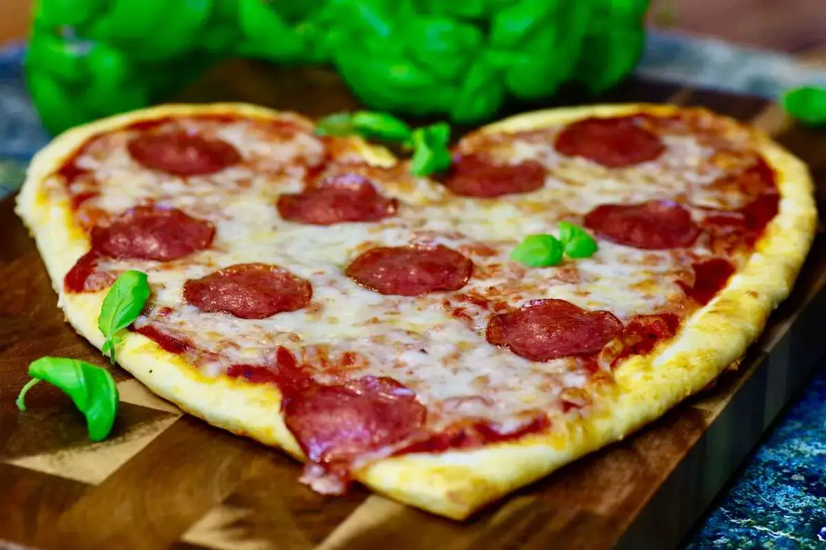 Pizza w kształcie serca z salami i bazylią, idealna na romantyczny wieczór we dwoje.