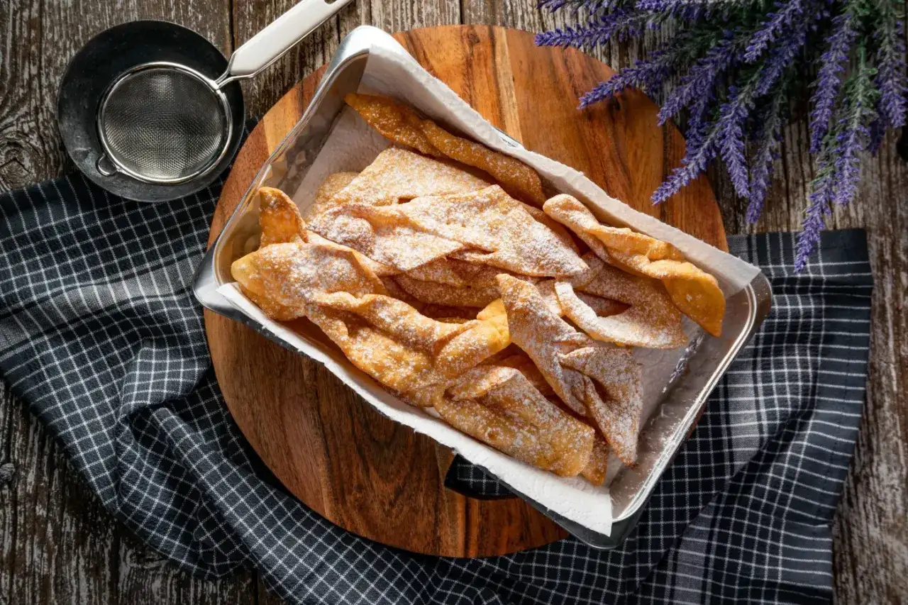 Chrupiące faworki, czyli pączki z ziemniakami Ewy Wachowicz, posypane cukrem pudrem, gotowe do degustacji.