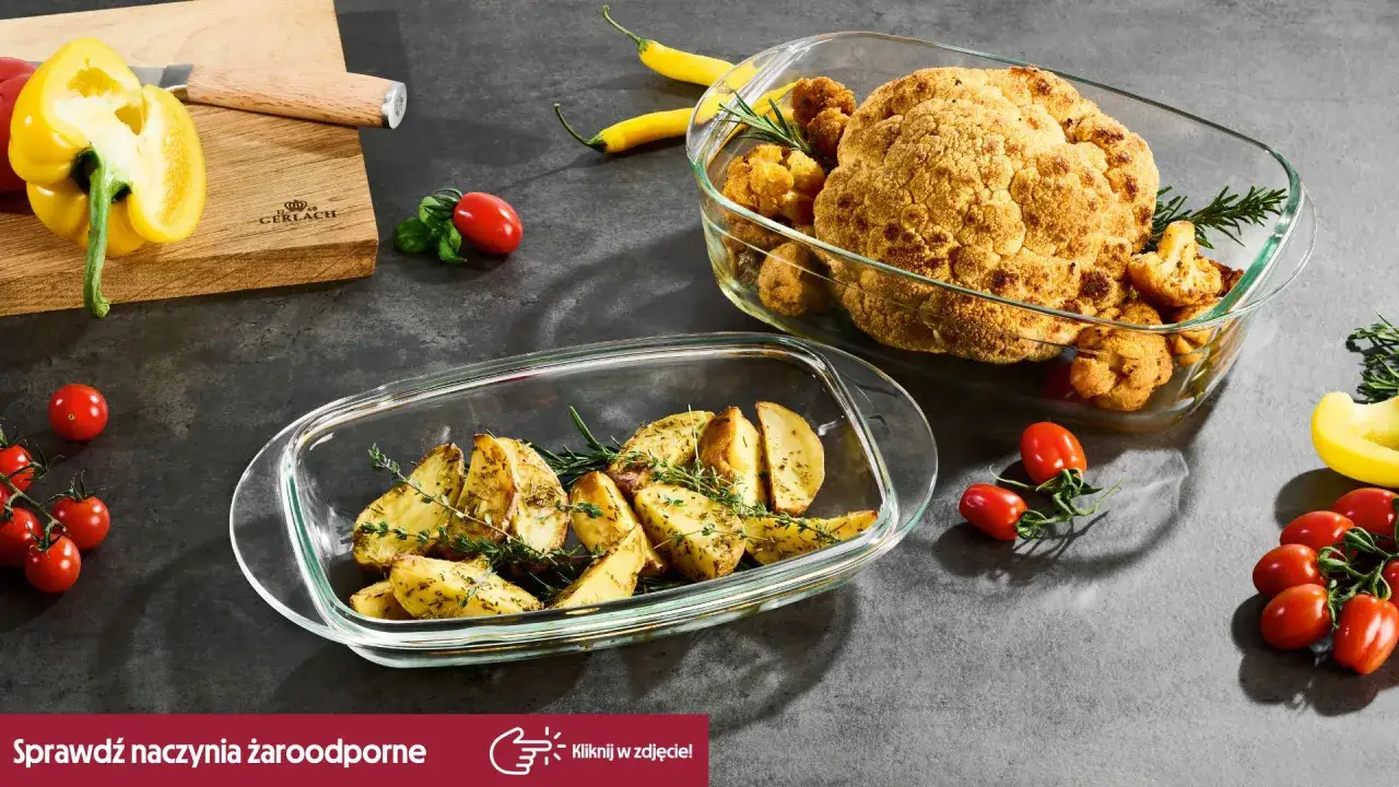 Pieczone ziemniaki i kalafior w naczyniu żaroodpornym. Obok pomidorki i papryka.