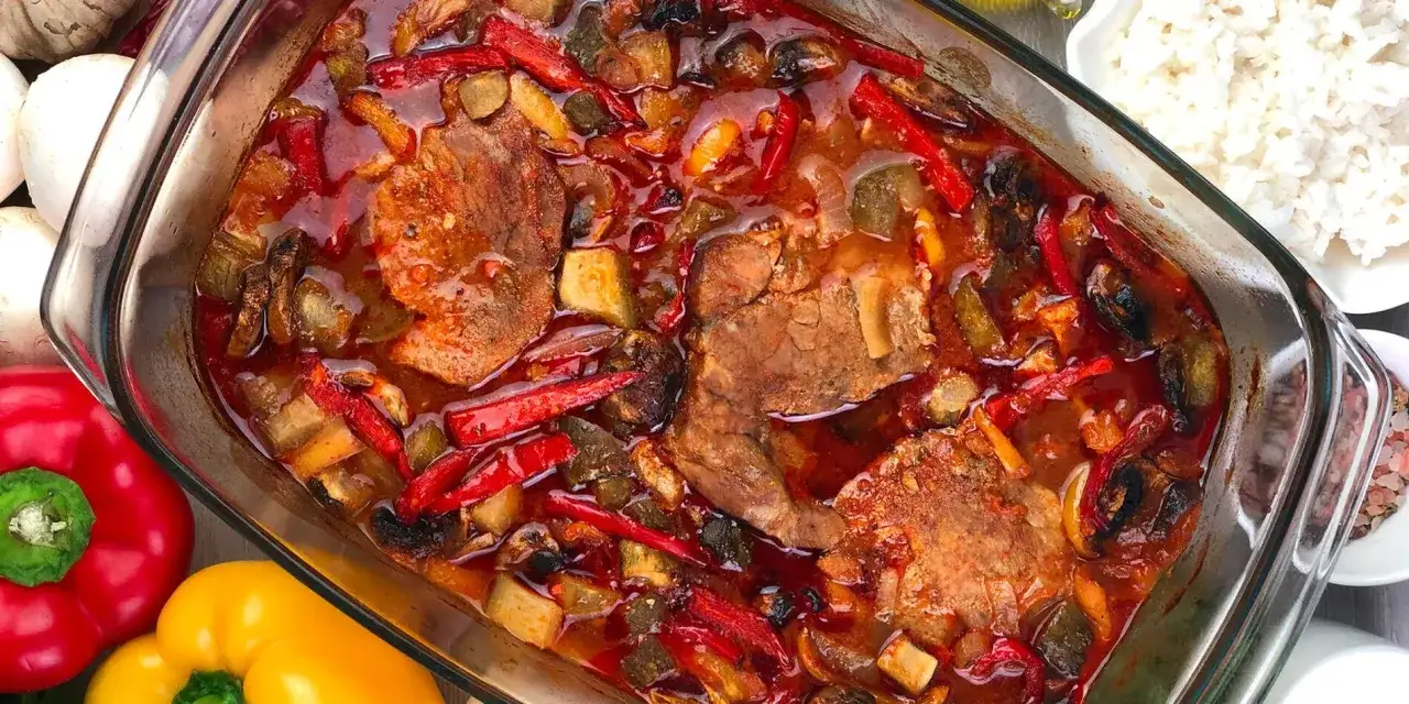 Karkówka po zbójnicku w plastrach, duszona z papryką i pieczarkami w aromatycznym sosie. Pyszne danie gotowe do podania.