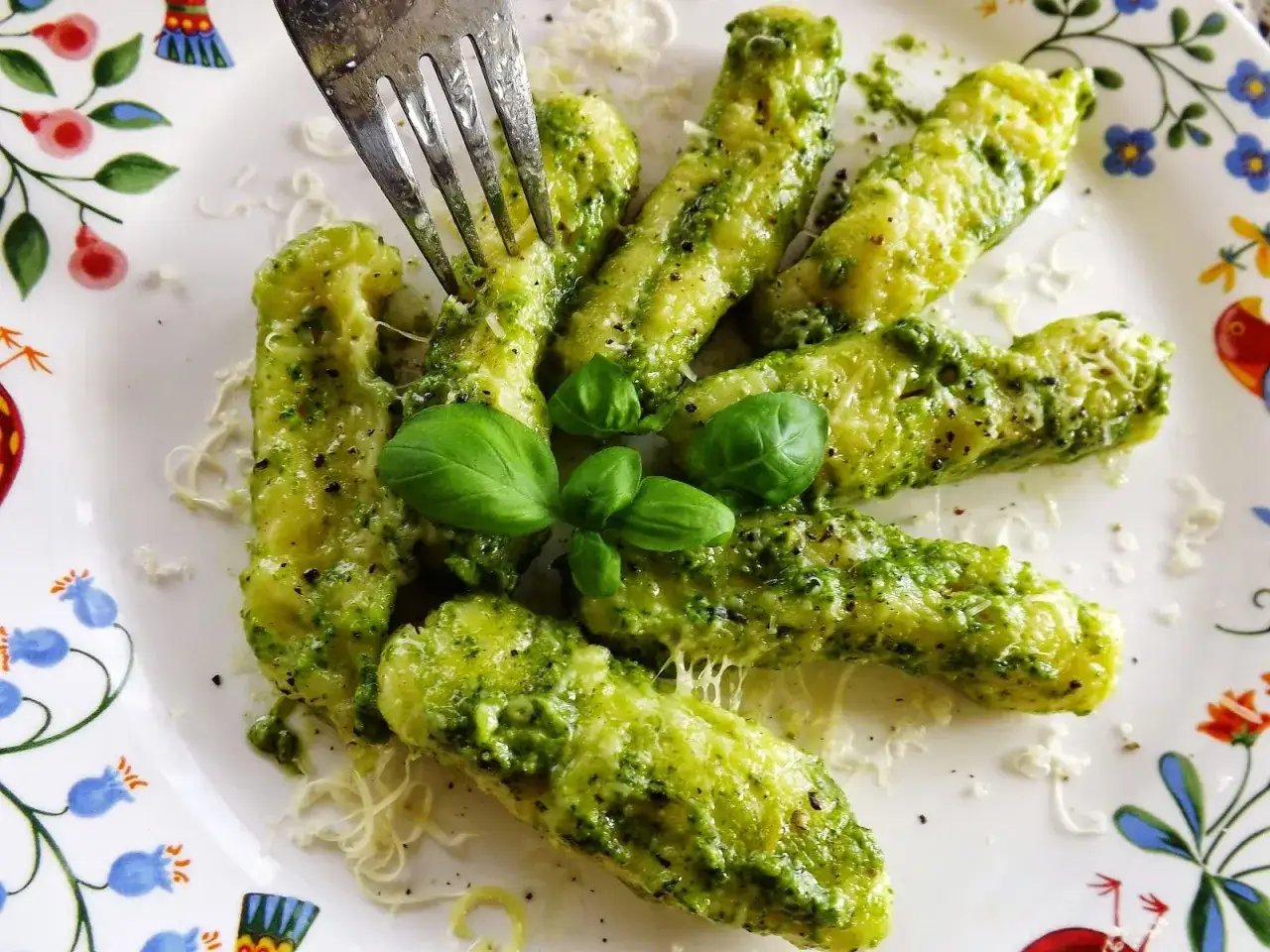 Pyszne, domowe gnocchi z pesto, posypane parmezanem i udekorowane listkami bazylii. Widok, który pobudza apetyt!
