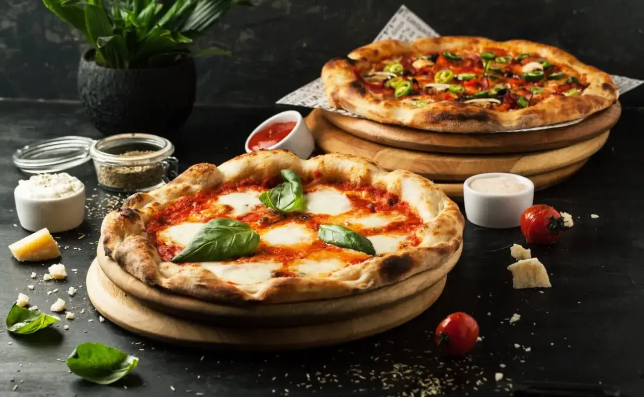Dwie pyszne pizze, idealne na narodowy dzień pizzy. Jedna klasyczna Margherita, druga z dodatkami.