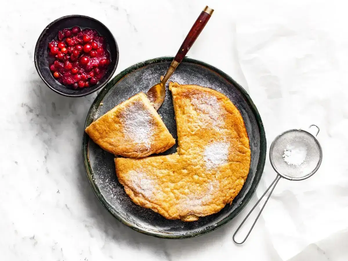Puszysty omlet z airfryera, posypany cukrem pudrem, podany z żurawiną. Idealny na śniadanie.