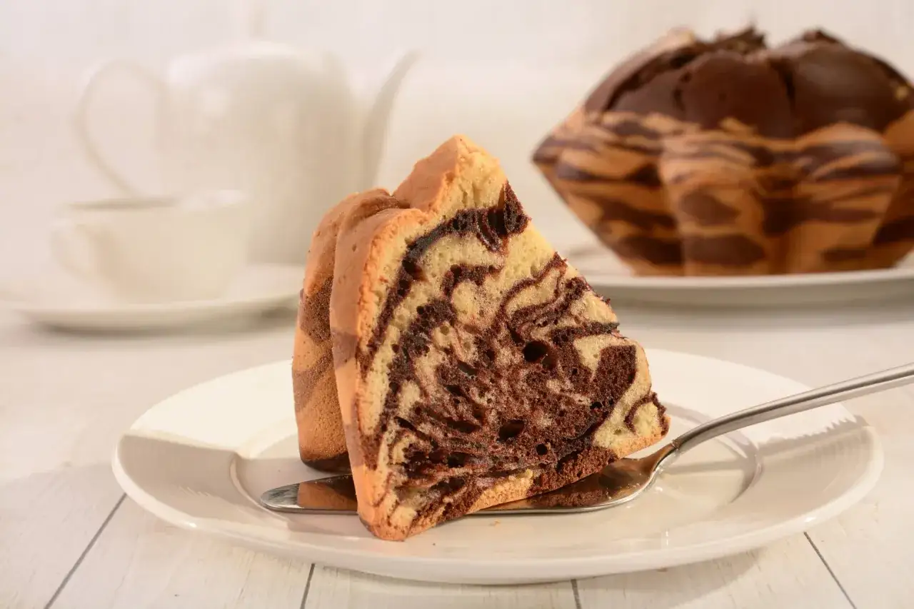 Pyszna babka zebra przepis na udane ciasto. Kawałek ciasta na talerzyku z widocznym wzorem.