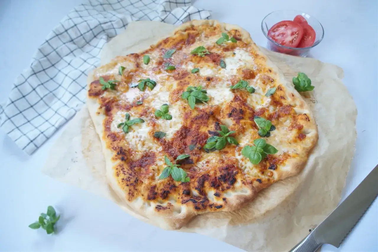 Pyszna pizza margerita z pomidorami i bazylią, gotowa do podania.