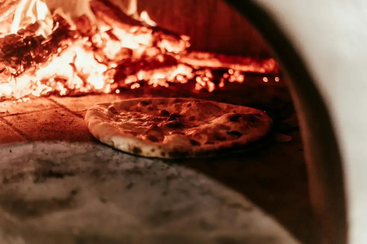 Pyszna pizza wypiekana w piecu opalanym drewnem w klimatycznej pizzerii Stare Miasto.