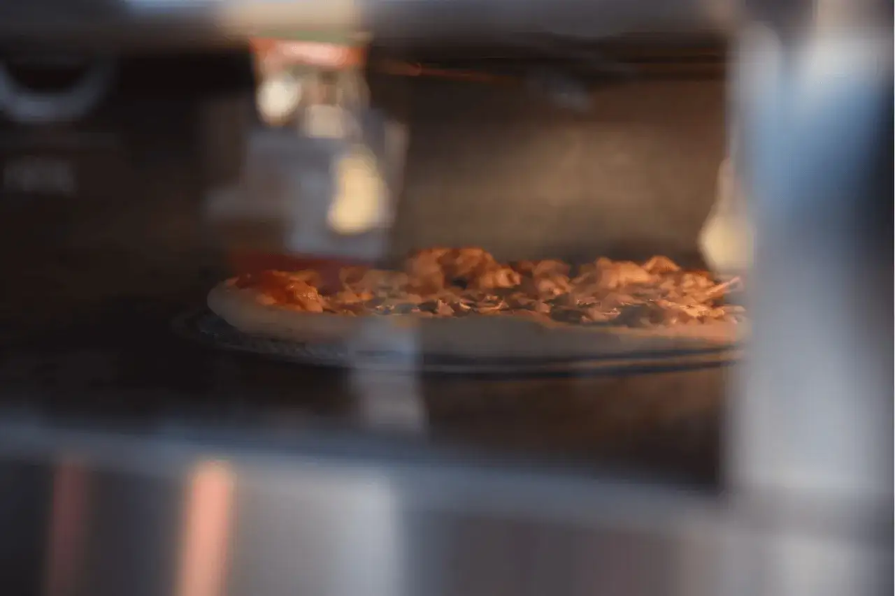 Pizza w piekarniku, gotowa do pieczenia. Czy pizzę można zamrozić? Tak, po upieczeniu i ostygnięciu.