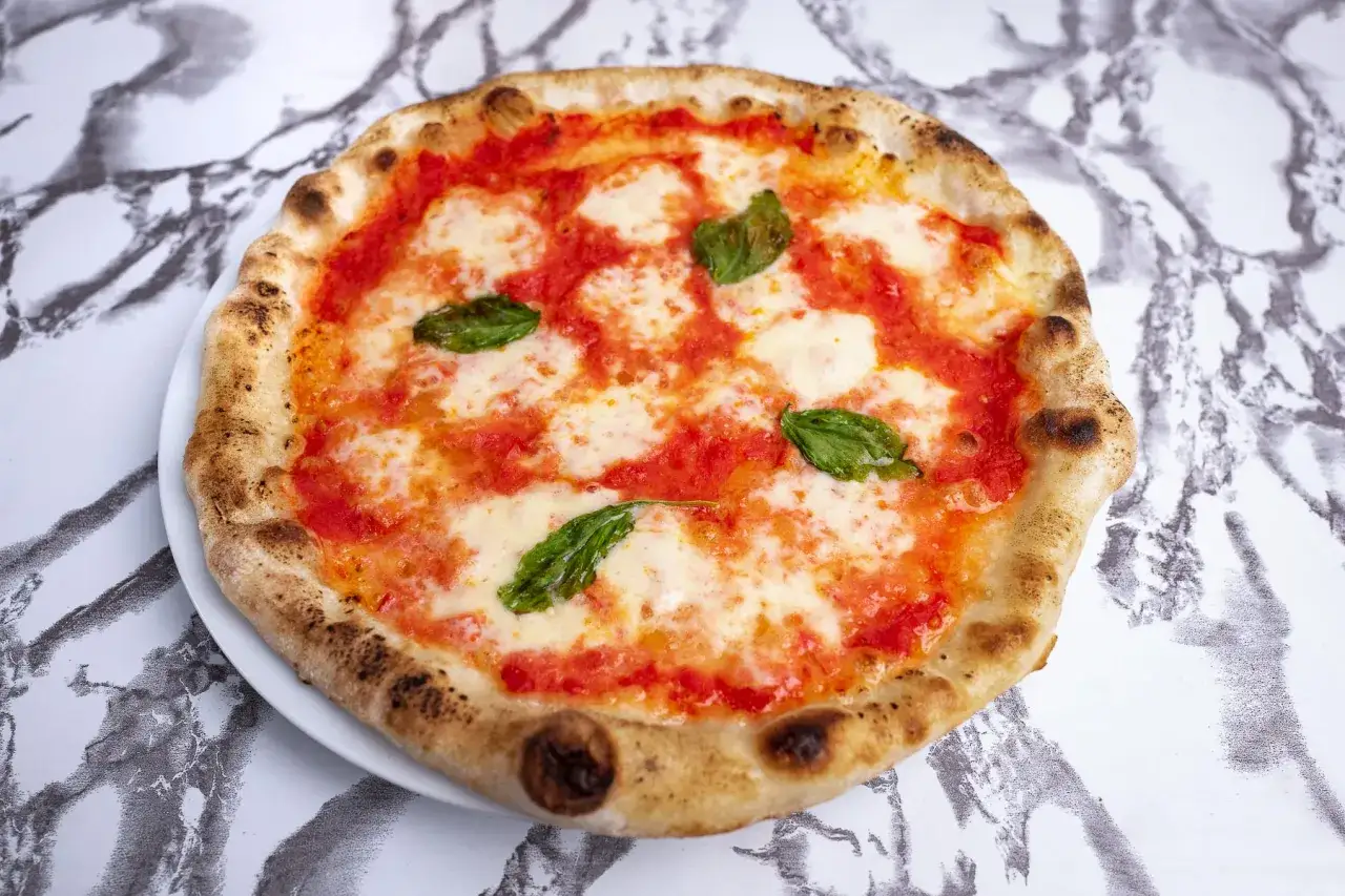 Klasyczna pizza neapolitańska z pomidorami, mozzarellą i bazylią. Idealna na lekki posiłek, choć warto sprawdzić jej pizza neapolitańska kcal.