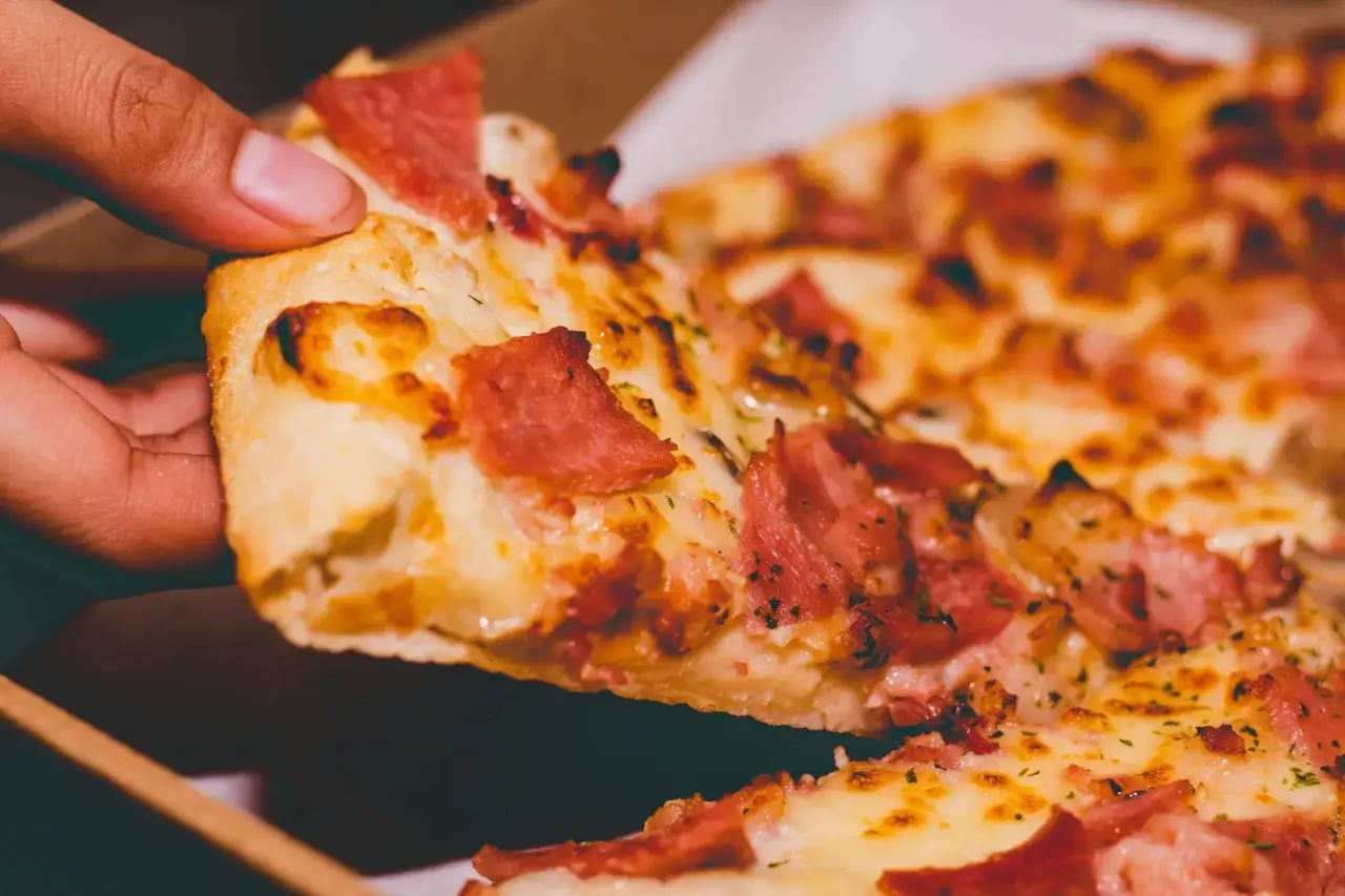 Kto wymyślił pizzę hawajską? Oto kawałek tej kontrowersyjnej pizzy z szynką i serem, który budzi dyskusje.