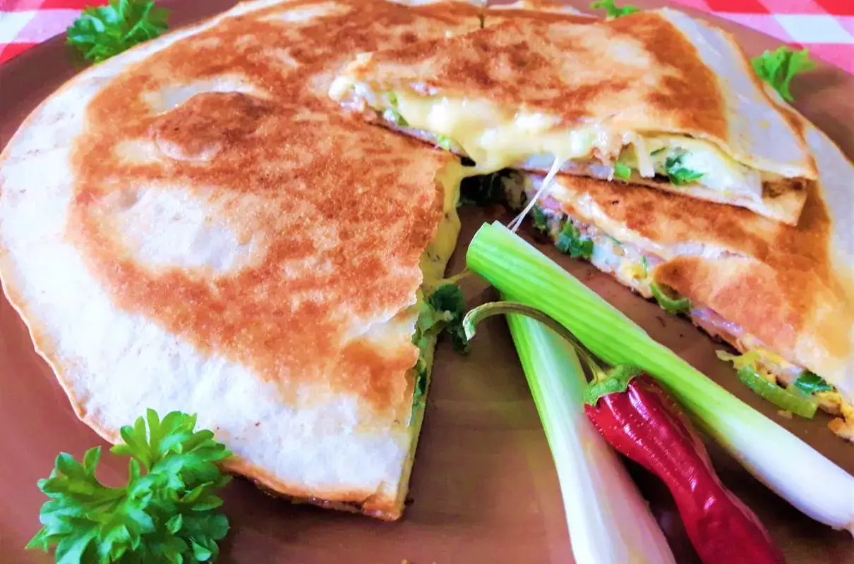 Szybka kolacja z niczego: złocista quesadilla z ciągnącym serem, zieloną cebulką i papryczką chili.