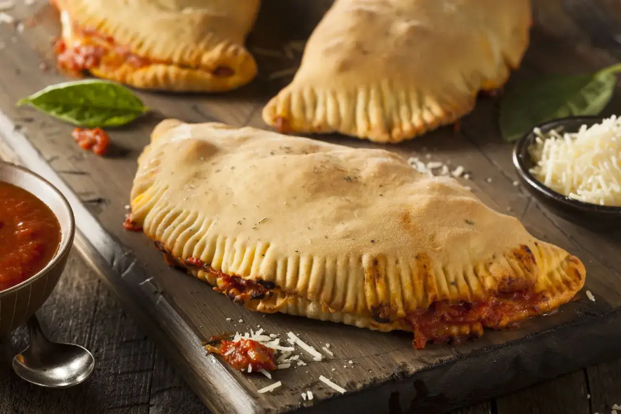 Złociste calzone z sosem pomidorowym i serem, idealne na szybki posiłek. Pamiętaj o umiarze, bo pizza calzone ma swoje kcal!